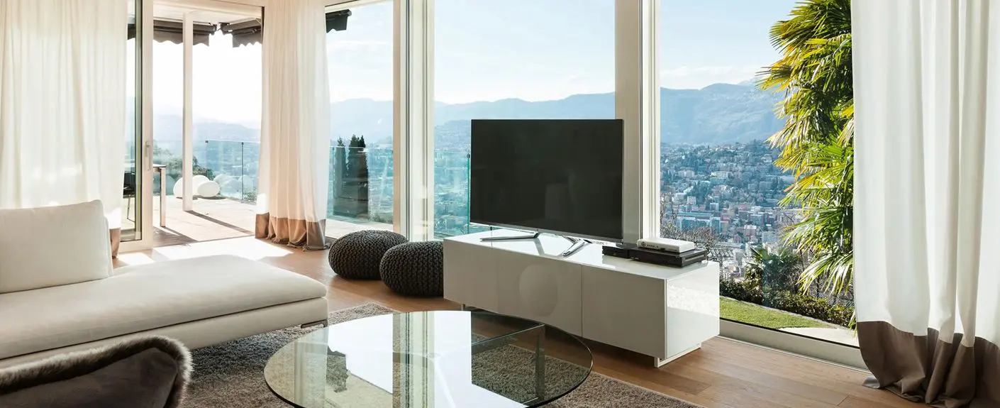 A living room with a large window and a television.