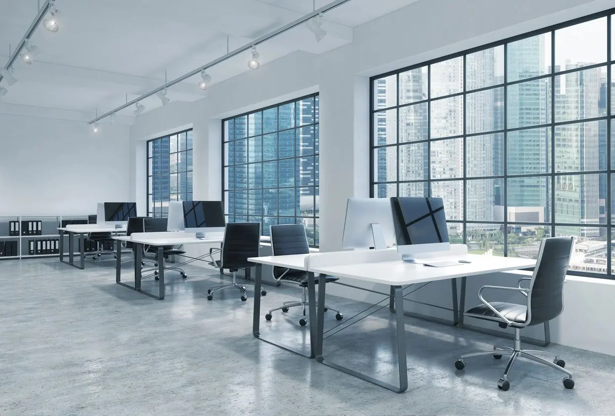 A row of desks with computers on top of them.