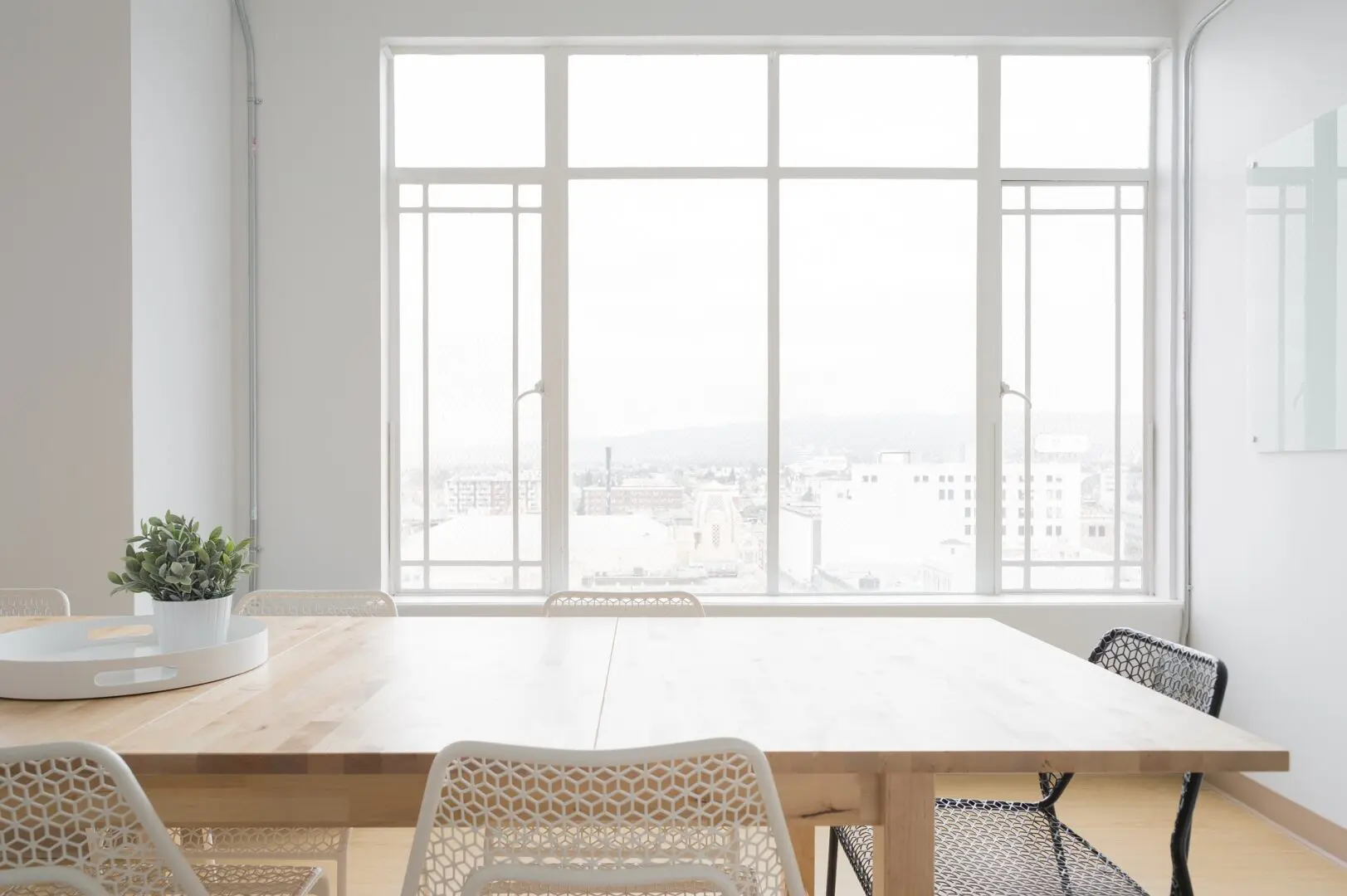 A table with chairs and a window in the background